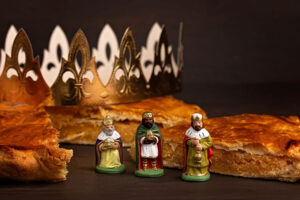 King cake or galette des rois in French. Traditional epiphany pie with golden paper crown and tiny charms.