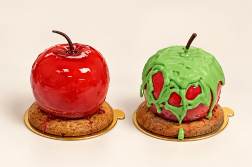 Red Apple Halloween desserts, one decorated with green chocolate, on their biscuit bases.